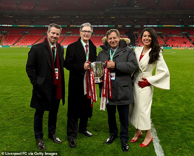 جون دبليو هنري (الثاني على اليسار) وزوجته ليندا بيزوتي هنري (أقصى اليمين) وتوم فيرنر (الثالث من اليسار) ، أصحاب نادي ليفربول لكرة القدم مع بيلي هوجان (أقصى اليسار) ، الرئيس التنفيذي لليفربول مع كأس EFL Carabao. في ملعب ويمبلي في فبراير 2022 في لندن